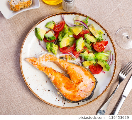 Baked salmon fillet served with avocado salad Baked salmon fillet served with avocado salad 139453629