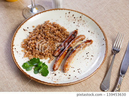Fried sausages served with buckwheat groats Fried sausages served with buckwheat groats 139453630