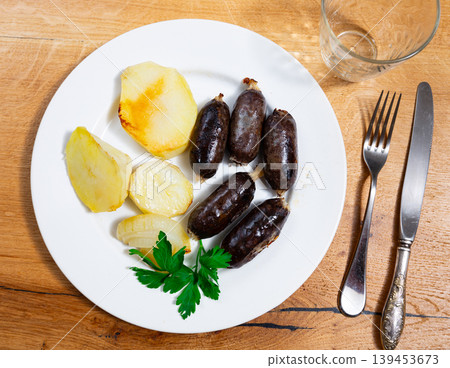 Several small black puddings sausages are toasted fried with onion rings Several small black puddings sausages are toasted fried with onion rings 139453673