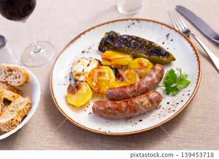Grilled sausages served with baked potato, pepper and eggplant Grilled sausages served with baked potato, pepper and eggplant 139453718