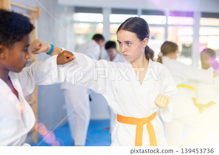 Boy and girl training karate techniques in studio Boy and girl training karate techniques in studio 139453736
