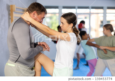 Coach and girl training self-defense techniques Coach and girl training self-defense techniques 139453774