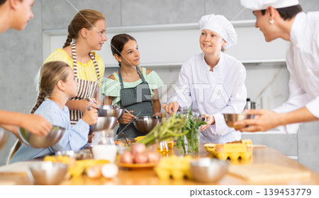 At cooking course, woman cook tells children about rules of cooking fluffy pancakes At cooking course, woman cook tells children about rules of cooking fluffy pancakes 139453779