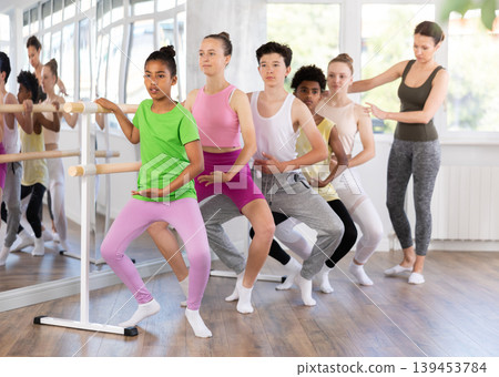 Teenage girl practicing plie position of ballet during choreography classes Teenage girl practicing plie position of ballet during choreography classes 139453784