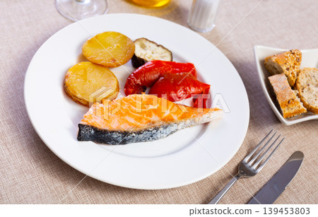Salmon fillet served with potatoes, peppers and eggplant Salmon fillet served with potatoes, peppers and eggplant 139453803