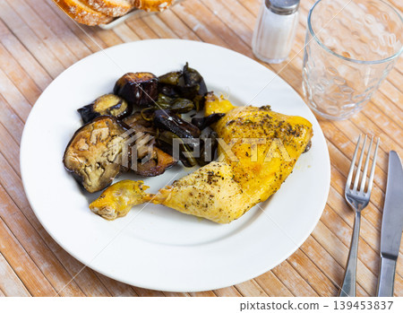 Chicken thigh with stewed eggplant on a ceramic plate cooked in cafe 139453837