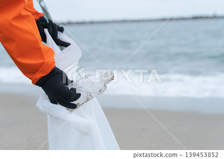 人們在海灘上撿拾被沖上岸的垃圾。 人們在海灘上撿拾被沖上岸的垃圾。 139453852