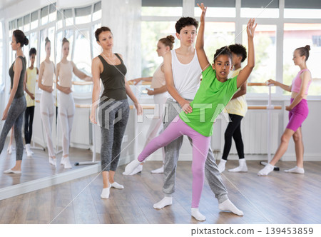 Teenage girl practicing ballet positions in pair with boy in dance studio 139453859