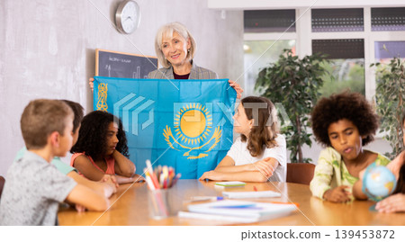 Friendly female teacher tells the pupils the history of Kazakhstan 139453872