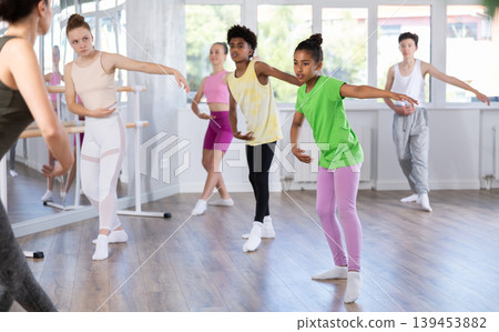 Group of teenage dancers training ballet in studio Group of teenage dancers training ballet in studio 139453882