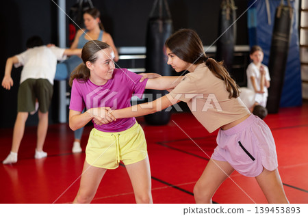Two teenage girls practice self-defense in pairs Two teenage girls practice self-defense in pairs 139453893