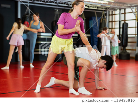 Teenage girl sparring with boy during training 139453910