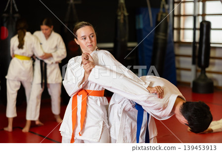 Children athletes in pair conduct training battle in oriental fighting technique 139453913