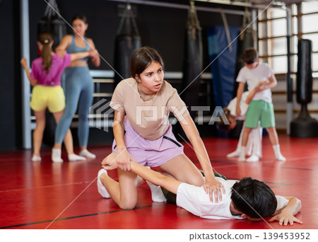 Teenage boy and girl practice self-defense in pairs Teenage boy and girl practice self-defense in pairs 139453952