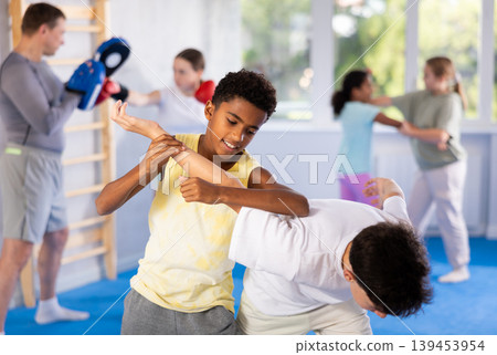 African teenager practicing painful armlock in sparring with boy at self defence training African teenager practicing painful armlock in sparring with boy at self defence training 139453954