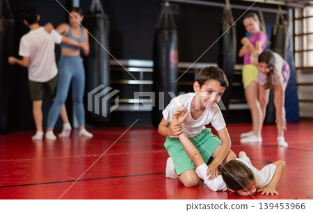 Boys practice self-defense strikes in the gym Boys practice self-defense strikes in the gym 139453966