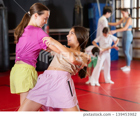 Girls practice self-defense strikes in the gym Girls practice self-defense strikes in the gym 139453982