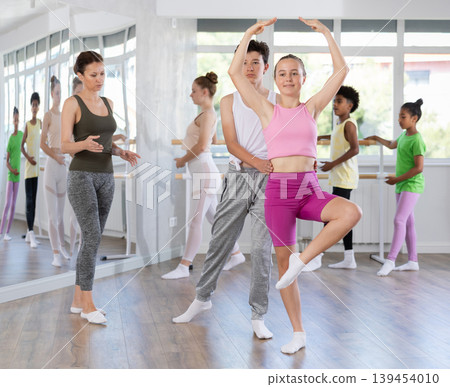 Teenage girl practicing ballet positions in pair with boy in dance studio 139454010