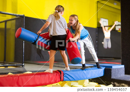 Teen girl having fun on battle beam with tween girl Teen girl having fun on battle beam with tween girl 139454037