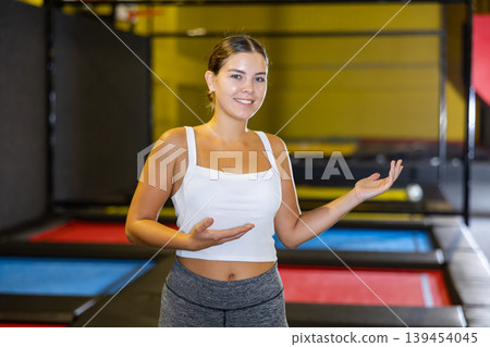 Teacher with children in trampoline center against background of children playing and jumping on trampoline 139454045
