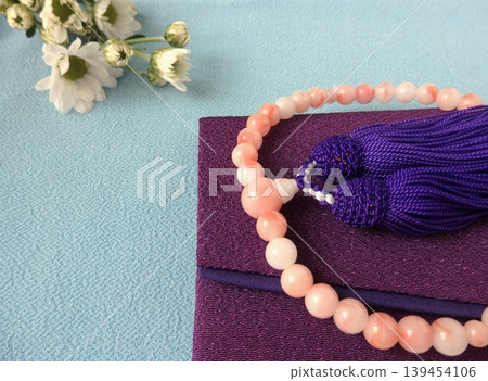 White chrysanthemums and prayer beads: A scene from a Buddhist ceremony. White chrysanthemums and prayer beads: A scene from a Buddhist ceremony. 139454106