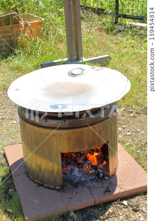 A stove made from a stainless steel washing tub and a stainless steel drum lid, using iron plates. A stove made from a stainless steel washing tub and a stainless steel drum lid, using iron plates. 139454814