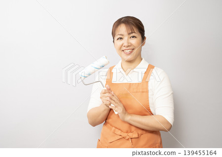A woman working as a house cleaner, carrying a carpet cleaner. A woman working as a house cleaner, carrying a carpet cleaner. 139455164