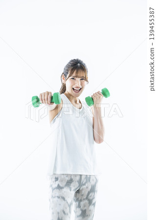 Young women sportswear looking at the camera dumbbell punch Young women sportswear looking at the camera dumbbell punch 139455387