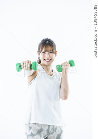 Young women sportswear looking at the camera dumbbell punch Young women sportswear looking at the camera dumbbell punch 139455388