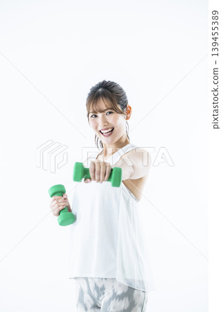 Young women sportswear looking at the camera dumbbell punch 139455389