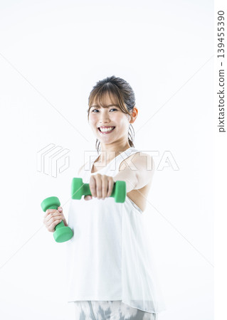 年輕女子運動服看著相機啞鈴拳 年輕女子運動服看著相機啞鈴拳 139455390
