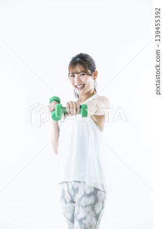 Young women sportswear looking at the camera dumbbell punch Young women sportswear looking at the camera dumbbell punch 139455392