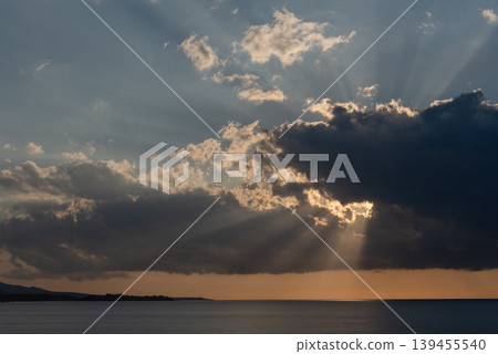 陽光透過雲層間的縫隙，灑向海面上的各個方向。 139455540