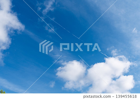 Blue sky with clouds and airplane contrail over England, UK, for weather or travel concept Blue sky with clouds and airplane contrail over England, UK, for weather or travel concept 139455618