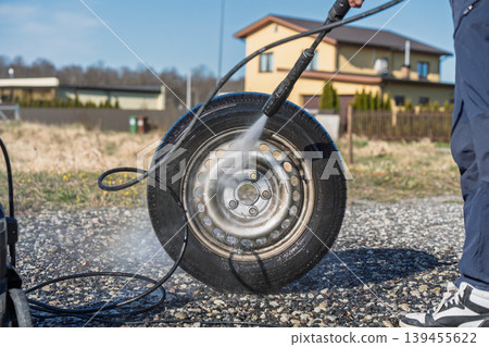Car tire cleaning with high pressure washer, maintenance and care on driveway outdoors Car tire cleaning with high pressure washer, maintenance and care on driveway outdoors 139455622