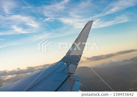 Airplane wing view over Nice, France at sunset with blue sky and scattered clouds visible from 139455642