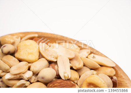 Close-up of a nut platter on a wooden plate against a white background. Close-up of a nut platter on a wooden plate against a white background. 139455866