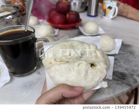 Hand Holding Steamed Baozi Bun Filled With Savory Minced Meat And Petai Hand Holding Steamed Baozi Bun Filled With Savory Minced Meat And Petai 139455972