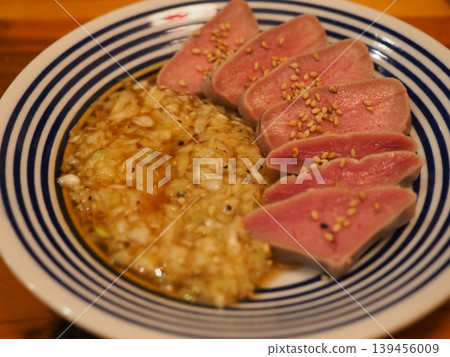 Izakaya's exquisite snacks: Thick-cut beef tongue sashimi style with green onion and salt sauce and slow-cooked. Izakaya's exquisite snacks: Thick-cut beef tongue sashimi style with green onion and salt sauce and slow-cooked. 139456009