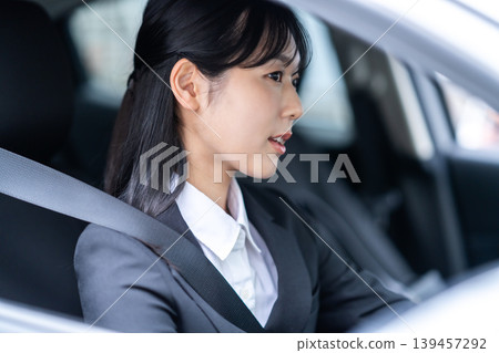 A businesswoman smiles in the driver's seat of a car. Safe driving. Lifestyle. Outside sales. A businesswoman smiles in the driver's seat of a car. Safe driving. Lifestyle. Outside sales. 139457292