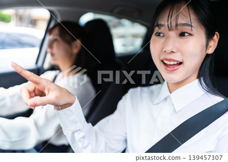 一位微笑的女士開車,她的朋友坐在副駕駛座上。 (駕駛生活方式) 一位微笑的女士開車,她的朋友坐在副駕駛座上。 (駕駛生活方式) 139457307