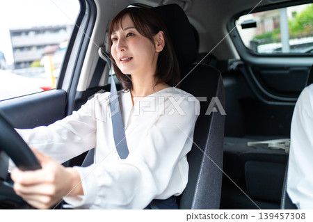 一位微笑的女士開車,她的朋友坐在副駕駛座上。 (駕駛生活方式) 一位微笑的女士開車,她的朋友坐在副駕駛座上。 (駕駛生活方式) 139457308