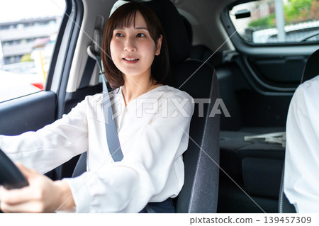 一位微笑的女士開車，她的朋友坐在副駕駛座上。 （駕駛生活方式） 139457309