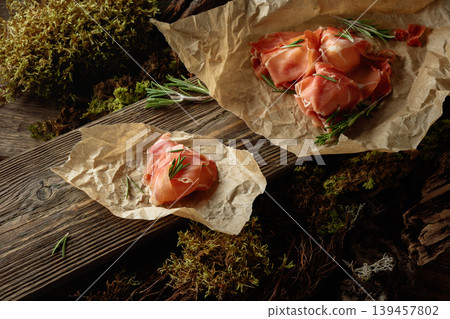 Prosciutto slices with rosemary wrapped in paper. Prosciutto slices with rosemary wrapped in paper. 139457802