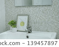 Minimalist bathroom interior featuring a sink, small plant, and framed art. 139457897