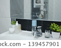 Aesthetic bathroom sink counter with skincare bottles, potted succulents, and clean tiles. 139457901