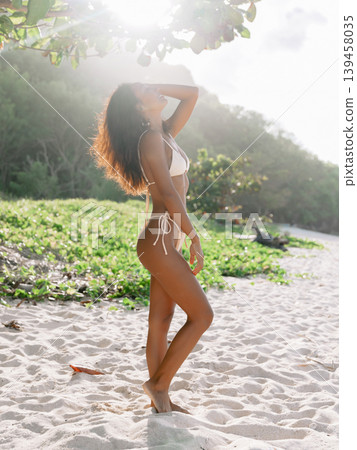 Gorgeous woman in bikini posing on sandy beach with sunshine Gorgeous woman in bikini posing on sandy beach with sunshine 139458035