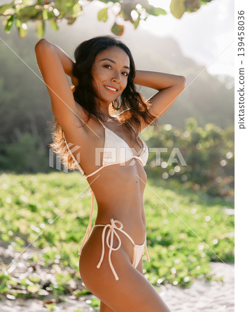 Fashionable balinese woman posing on sandy beach with sunshine Fashionable balinese woman posing on sandy beach with sunshine 139458036