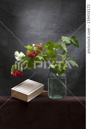 Still life with a book and a branch of red viburnum Still life with a book and a branch of red viburnum 139458172