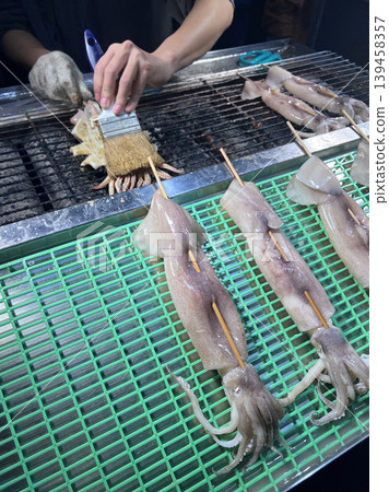 在台中的夜市拍攝攤販熟練的製作烤魷魚 在台中的夜市拍攝攤販熟練的製作烤魷魚 139458357